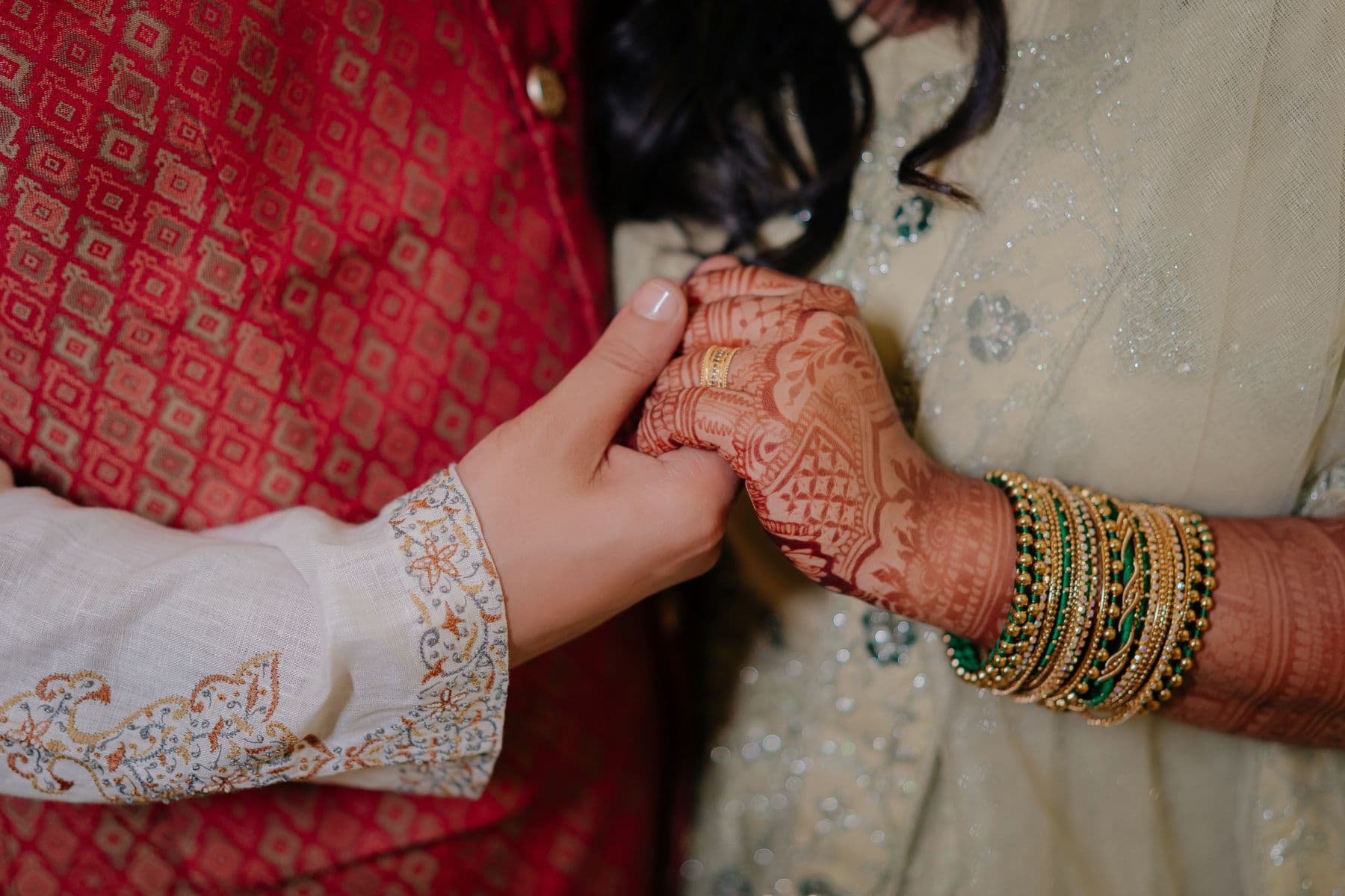 Hands held gently during a haldi blessing